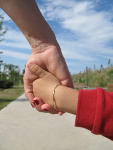 Mom and his young son holding hands